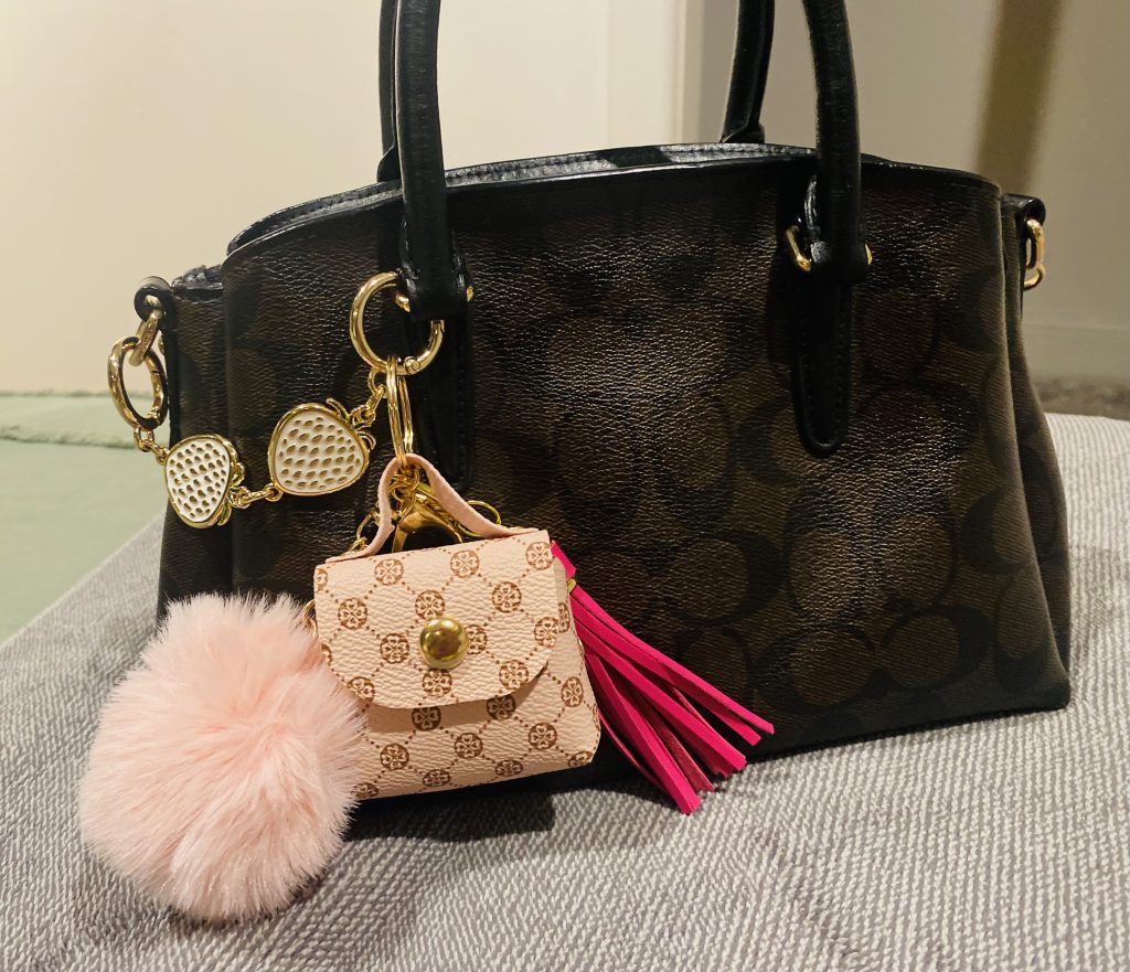 Handbag with mini bag, pom-pom and tassel trinkles